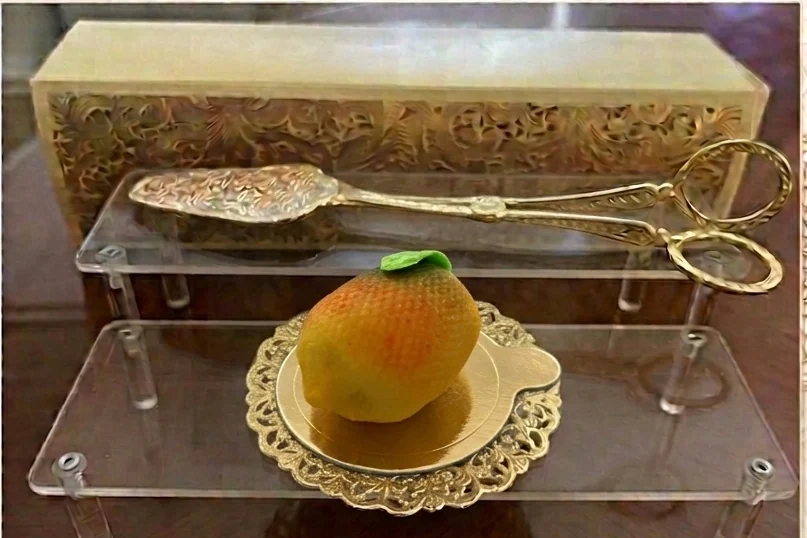 Pâtisserie jaune en forme de fruit avec une petite feuille verte