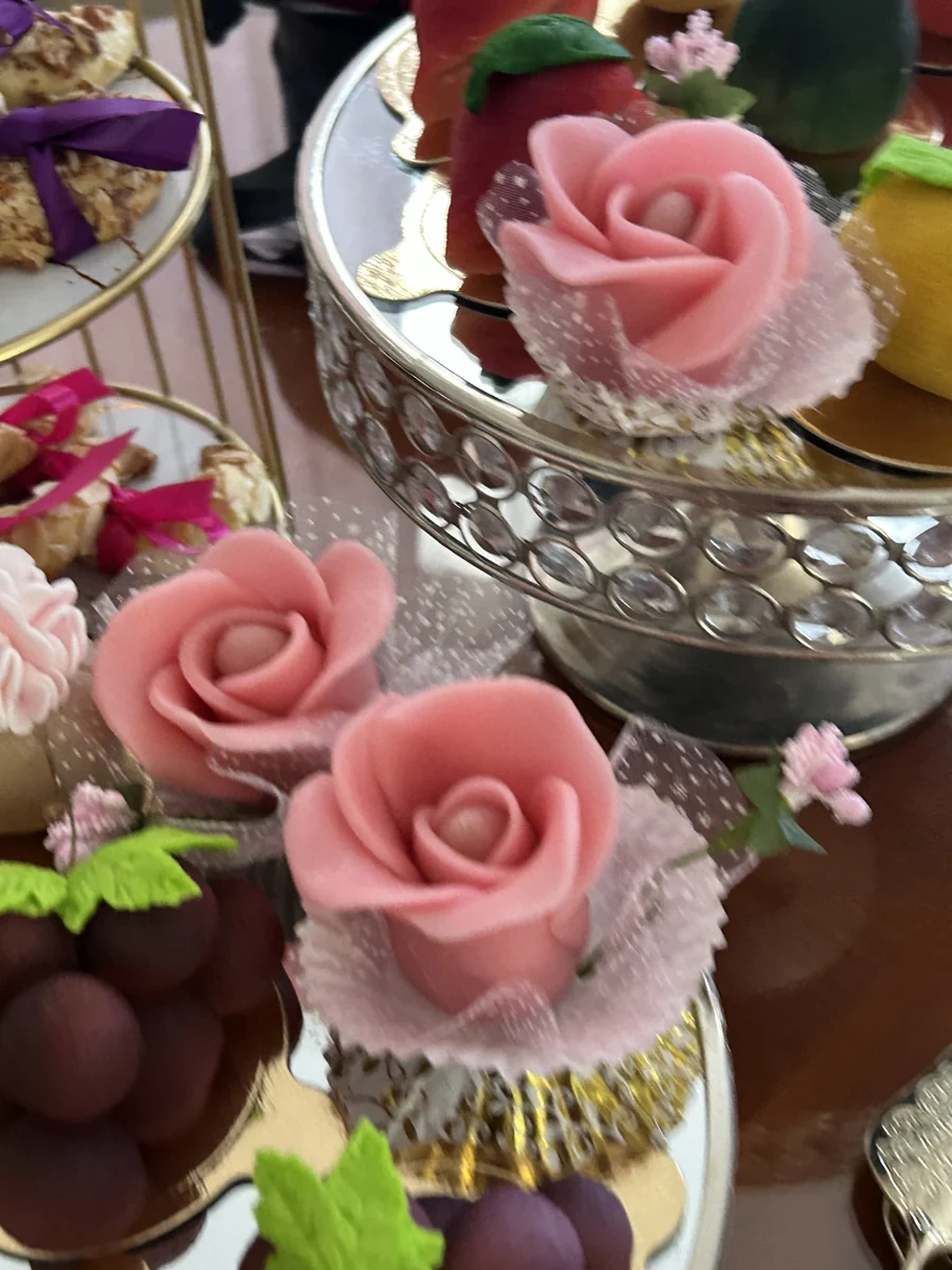 Petites pâtisseries décorées de roses roses et de fleurs blanches