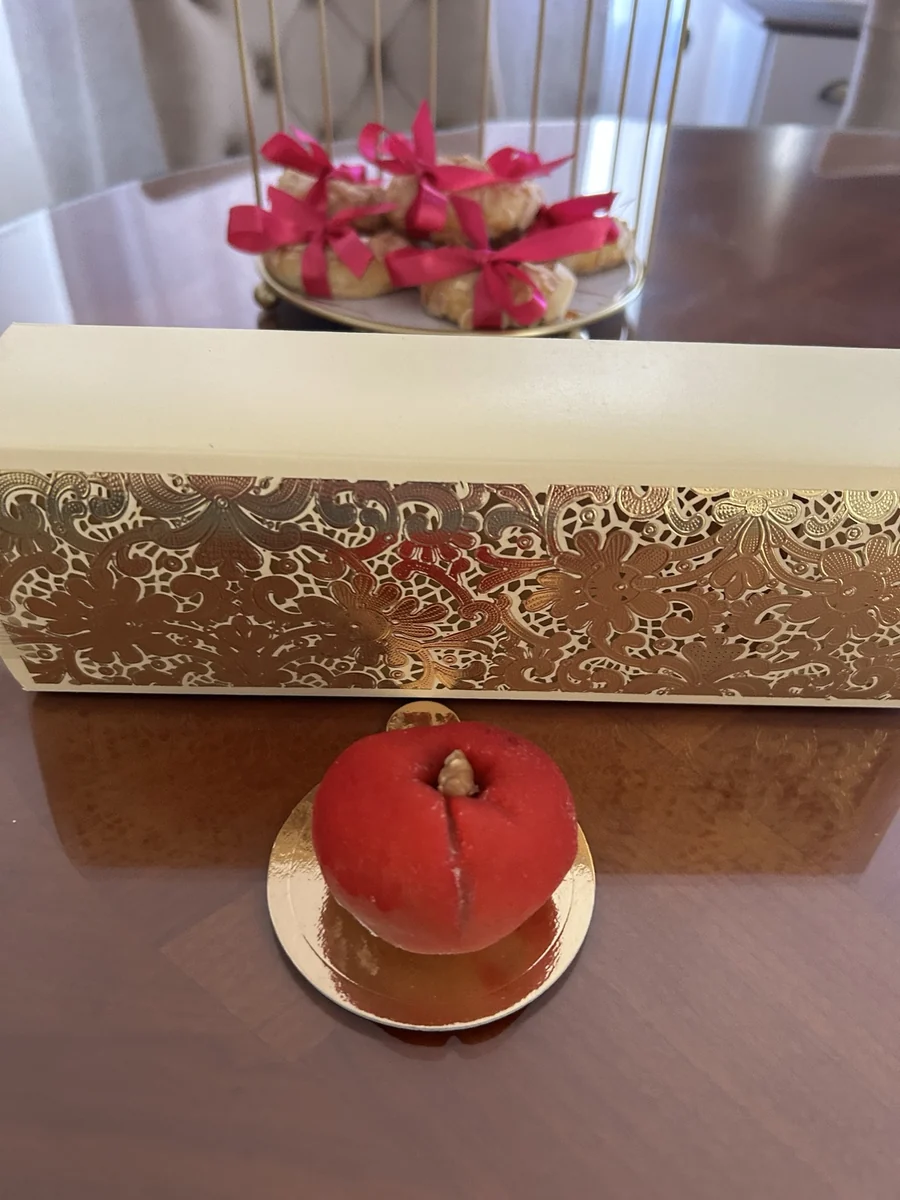 Petite pâtisserie en forme de pomme rouge avec une feuille verte