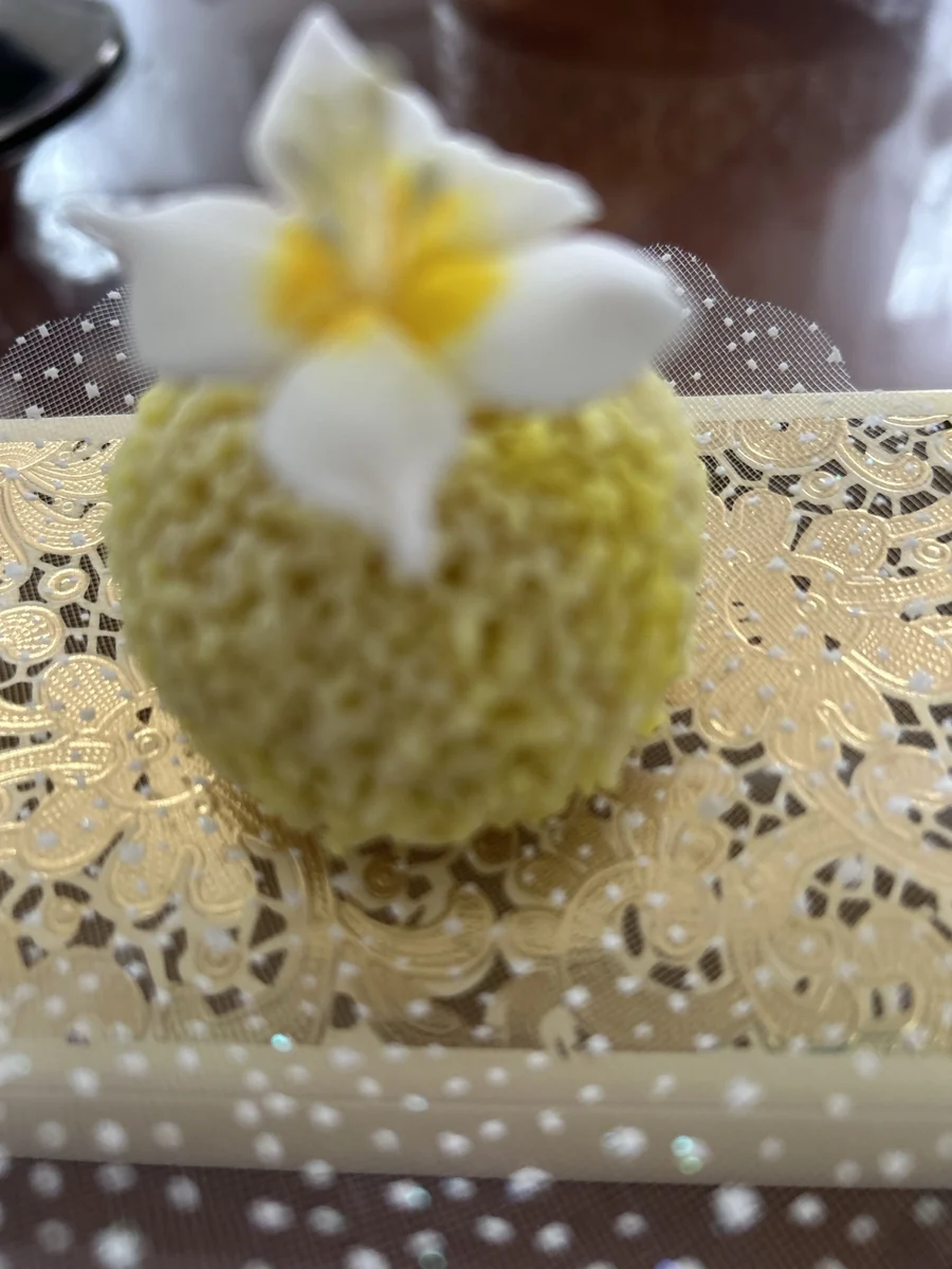 Petite pâtisserie ronde décorée d’une fleur blanche et jaune