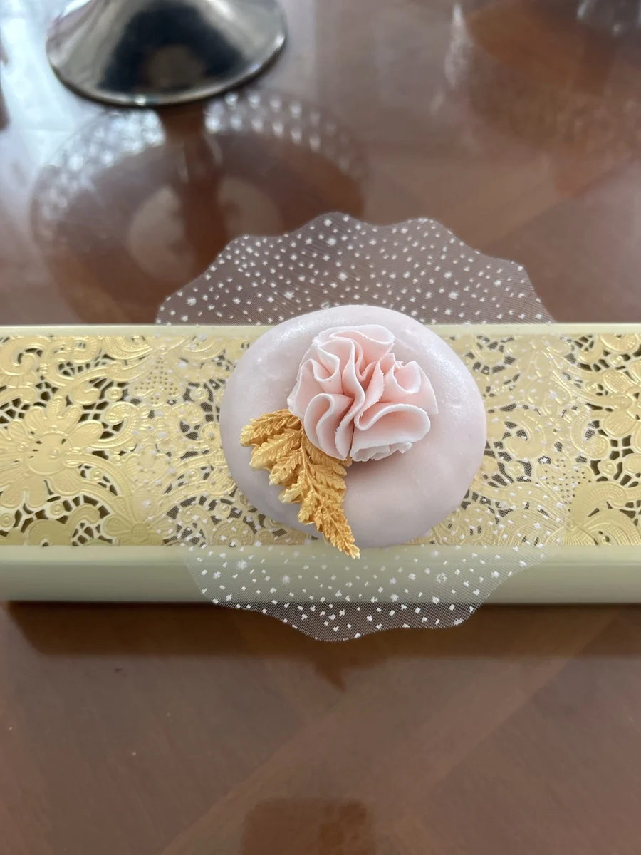 Pâtisserie ronde décorée d’une fleur rose et jaune