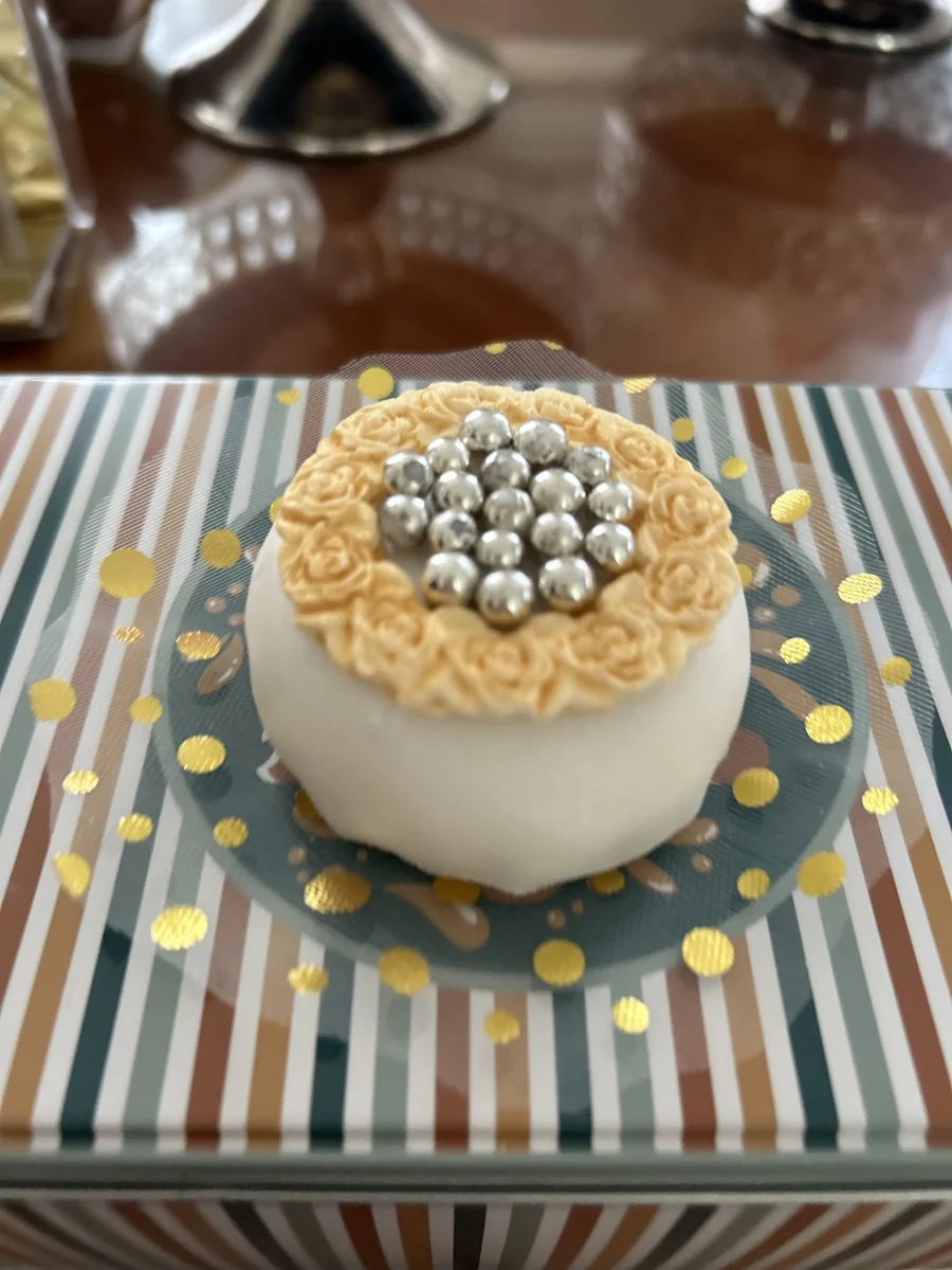 Pâtisserie ronde blanche surmontée de perles chocolatées
